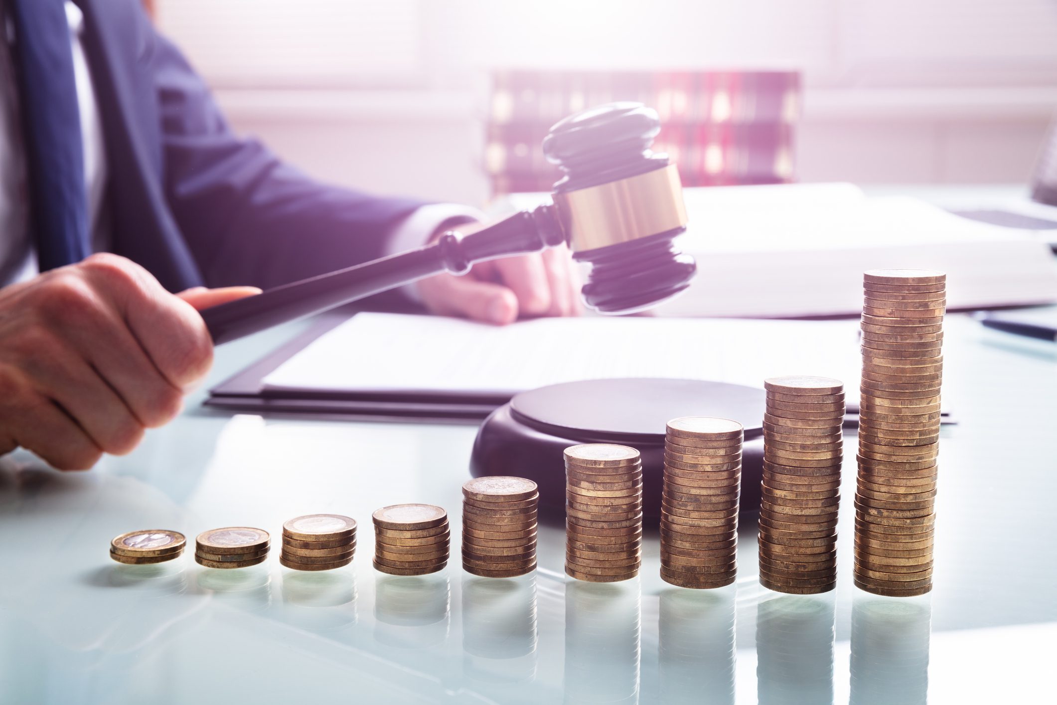Gavel near ascending coin stacks