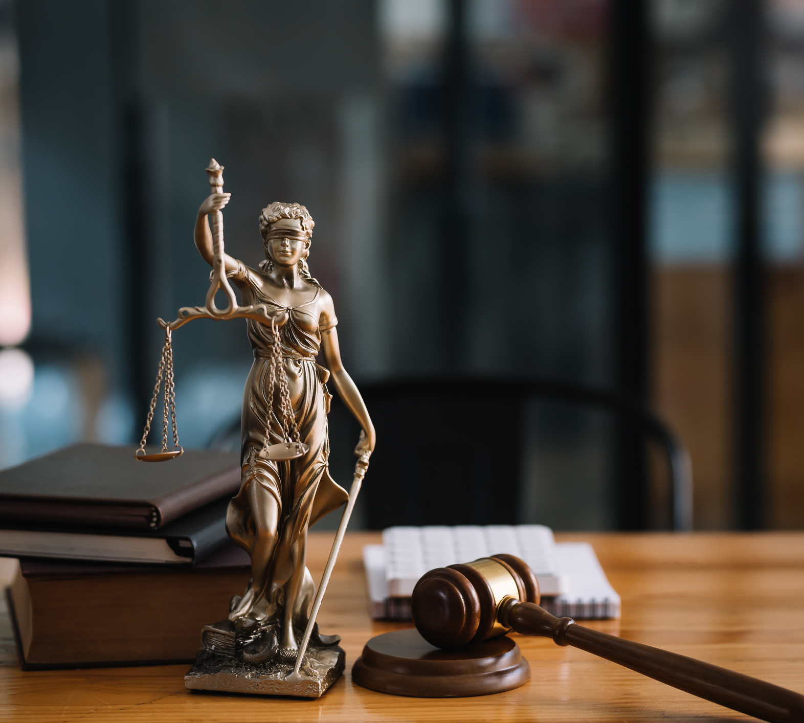 Justice statue beside legal books and gavel