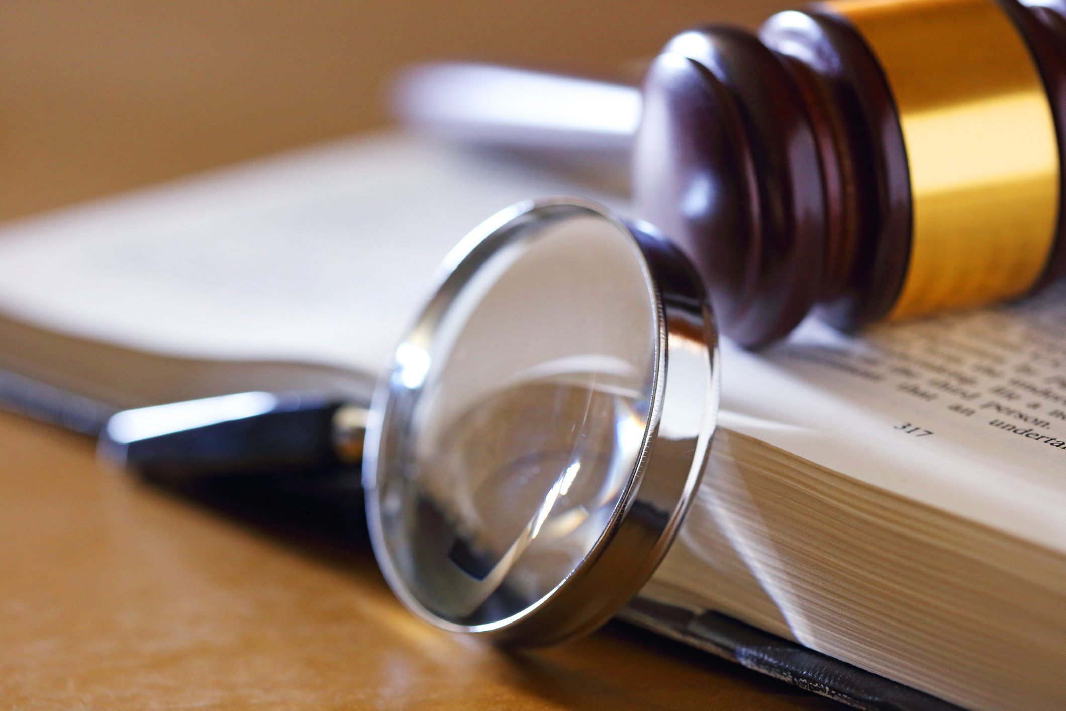 Magnifier and gavel beside book